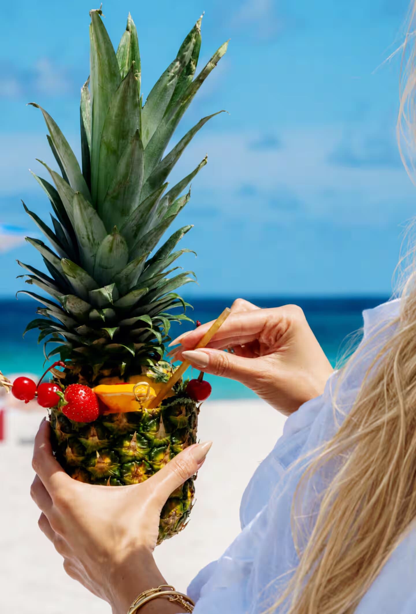 Pineapple cocktail in hand on the beach — the guests’ favorite drink at the Bentley Beach Club
